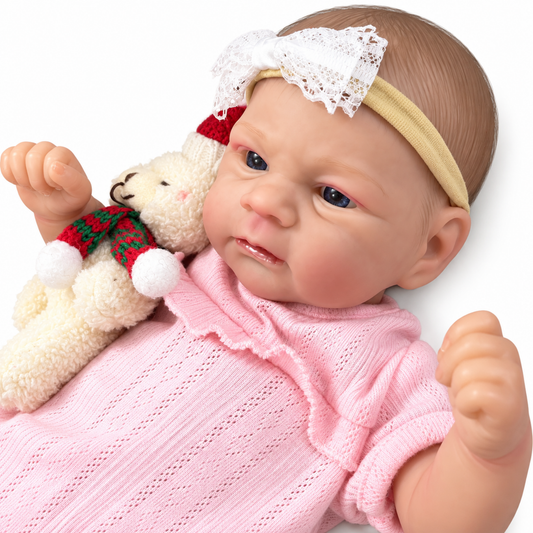 Close up of reborn baby doll face with lace bow headband cuddling teddy bear