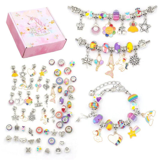 Pink gift box beside three finished charm bracelets and rows of loose beads and charms