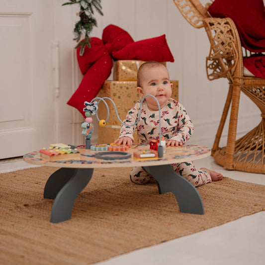 Baby playing with wooden activity table at home