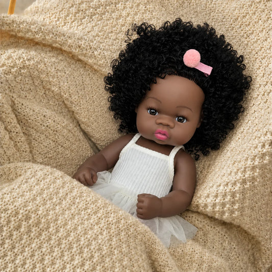 Curly hair baby doll close up on knit blanket wearing ballet outfit