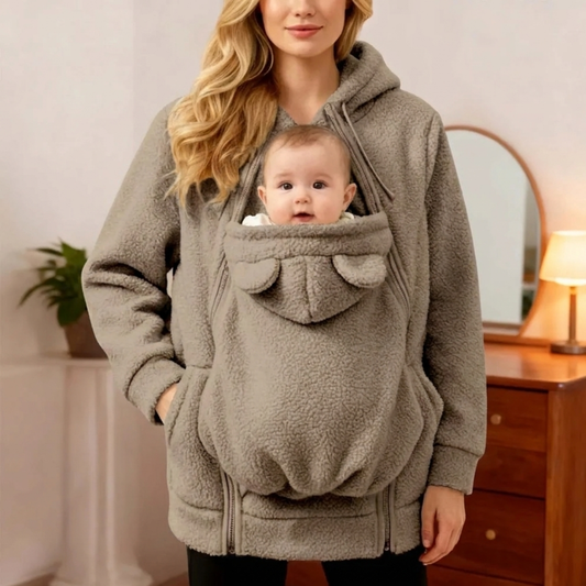 Mother wearing grey plush kangaroo-pocket babywearing hoodie coat carrying baby in the built-in pouch