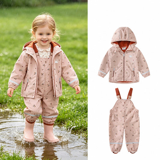 Girl in pink floral waterproof rain suit jacket and trousers splashing in a puddle, with matching flat-lay jacket and trousers shown alongside