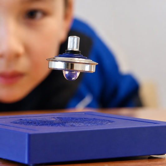 Close-up of the chrome levitating top hovering in mid-air over the blue magnetic base