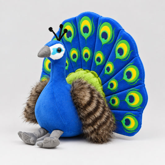 Peacock plush toy seen from a three-quarter side angle, showing the rounded royal blue body, striped faux-fur wings and upright fan tail